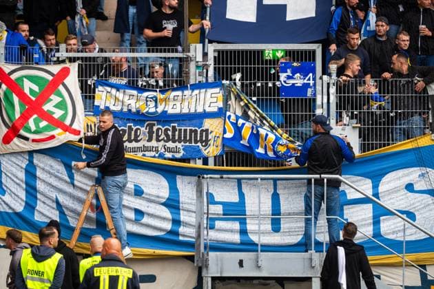 Jena , 270925, Soccer Regionalliga , FC Carl Zeiss Jena vs Chemnitzer FC in the picture Fans Ultras Jena Horda provoke interruption of the game by blocking two escape gates with banners and fans in the block