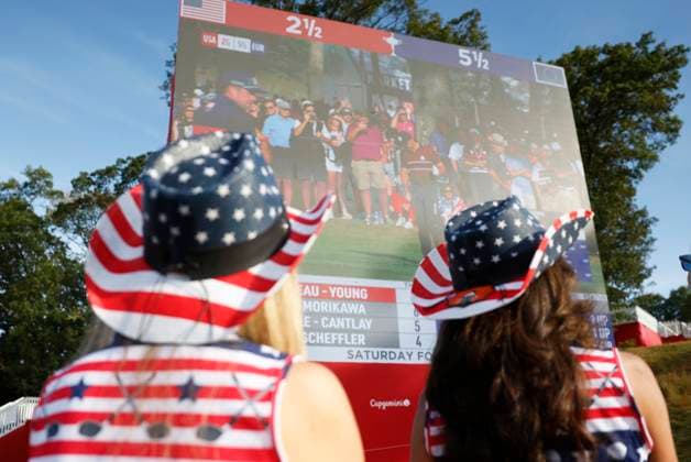 Fans wear the colors of the American Flag as they watch the scoreboards on day two as Team United States plays Team Europe in the 45th Ryder Cup at the Bethpage Black Course in Farmingdale, New York on Saturday, September 27, 2025. Europe has a 8.5 to 3.5 lead over the United States after the morning matches on the second day.  RYD20250927001 JOHNxANGELILLO