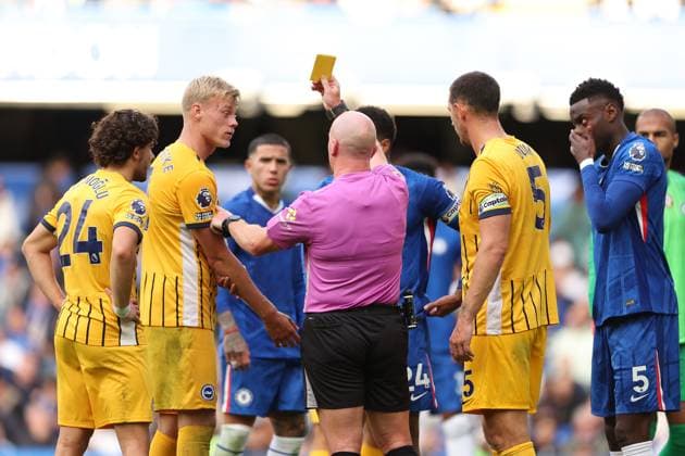 27th September 2025; Stamford Bridge, Chelsea, London, England: Premier League Football, Chelsea versus Brighton and Hove Albion; Referee Simon Hooper giving a yellow card to Jan Paul van Hecke of Brighton &amp; Hove Albion  JohnxPatrickxFletcher
