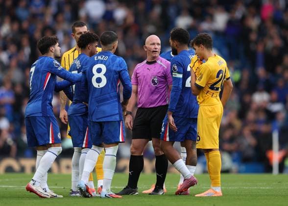 27th September 2025; Stamford Bridge, Chelsea, London, England: Premier League Football, Chelsea versus Brighton and Hove Albion; Referee Simon Hooper being surrounded by Chelsea players  JohnxPatrickxFletcher