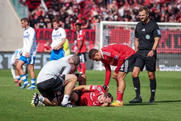 Adam Markhiyev 6 1FC Nuernberg is treated after a tackle, has to leave the field injured, with Referee Referee Marc Philip Eckermann, 1 FC Nuernberg vs Hertha BSC Berlin, DFL, 2 Bundesliga, Saison 2025 2026, Max Morlock Stadion, Hinrunde, 7 Spieltag, 28 09 2025 DFB regulations prohibit any use of photographs as image sequences and or quasi video Nuernberg Bayern Germany Copyright: xkolbert-press MartinxAgüerax