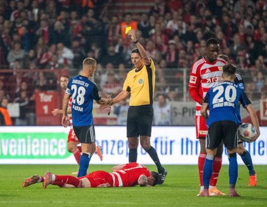Soccer, Men, Season 2025 2026, 1 Bundesliga 5 Matchday , 1 FC Union Berlin Hamburger SV, v l Miro Muheim Hamburger SV fouled Oliver Burke 1 FC Union Berlin , he sees a yellow card from referee Deniz Aytekin and thanks him, 28 09 2025, Copyright: xMatthiasxKochx