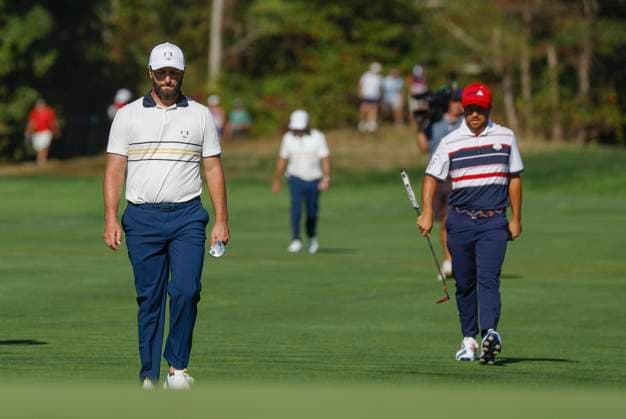 Jon Rahm (L) of Team Europe and Xander Schauffele of Team United States walk to the twelfth green during a single match on the final day of the 45th Ryder Cup at the Bethpage Black Course in Farmingdale, New York on Sunday, September 28, 2025. Europe has a 12 to 5 lead over the United States going into the final day.  RYD20250928931 JOHNxANGELILLO