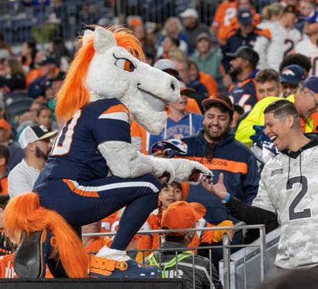 September 30, 2025, Denver, Colorado, USA: Broncos Mascot MILES hands over an autograph to a Broncos fan during the 2nd Half at Empower Field at Mile High Monday night. Broncos beat the Bengals 28-3. Denver USA - ZUMAav4_ 20250930_zaf_av4_017 Copyright: xHectorxAcevedox