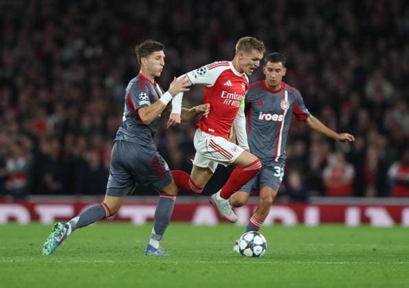 London, England, 1st October 2025. Panagiotis Retsos of Olympiakos tackles Martin Odegaard of Arsenal during the Arsenal vs Olympiacos UEFA Champions League match at the Emirates Stadium, London. Picture credit should read: David Klein Sportimage EDITORIAL USE ONLY. No use with unauthorised audio, video, data, fixture lists, club league logos or live services. Online in-match use limited to 120 images, no video emulation. No use in betting, games or single club league player publications. SPI_027_DK_Arsenal_Olympiakos SPI-4186-0024