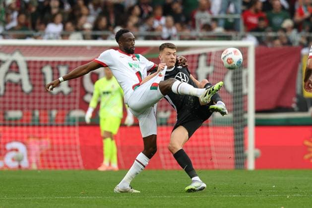 in duel, action, with Chrislain Matsima 5 FC Augsburg , Dzenan Pejcinovic 17 VfL Wolfsburg , FC Augsburg vs VfL Wolfsburg, Soccer, 1 Bundesliga, 6 Matchday, 04 10 2025 DFB regulations prohibit any use of photographs as image sequences and or quasi video Augsburg Bayern Germany Copyright: xkolbert-press ChristianxKolbertx