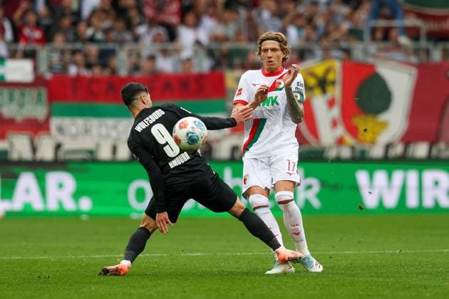 in duel, action, with Mohamed Amoura 9 VfL Wolfsburg , Kristijan Jakic 17 FC Augsburg , FC Augsburg vs VfL Wolfsburg, Soccer, 1 Bundesliga, 6 Matchday, 04 10 2025 DFB regulations prohibit any use of photographs as image sequences and or quasi video Augsburg Bayern Germany Copyright: xkolbert-press ChristianxKolbertx