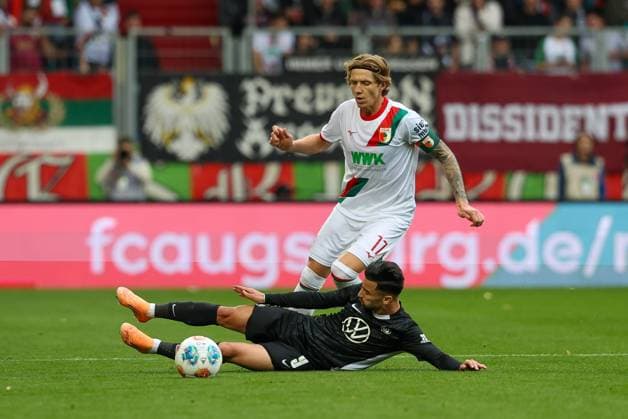 in duel, action, with Kristijan Jakic 17 FC Augsburg , Mohamed Amoura 9 VfL Wolfsburg , FC Augsburg vs VfL Wolfsburg, Soccer, 1 Bundesliga, 6 Matchday, 04 10 2025 DFB regulations prohibit any use of photographs as image sequences and or quasi video Augsburg Bayern Germany Copyright: xkolbert-press ChristianxKolbertx