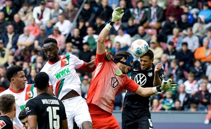 04 10 2025, xemx, Soccer 1 Bundesliga, FC Augsburg VfL Wolfsburg v l Chrislain Matsima FC Augsburg , Kamil Grabara VfL Wolfsburg , Vini Souza VfL Wolfsburg Zweikampf, Aktion, action, battle for the ball DFL DFB REGULATIONS PROHIBIT ANY USE OF PHOTOGRAPHS as IMAGE SEQUENCES and or QUASI VIDEO Augsburg
