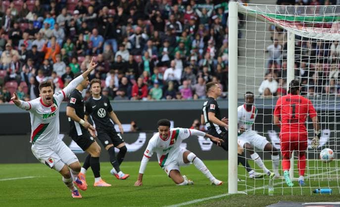 04 10 2025, 1 Bundesliga , FC Augsburg vs VfL Wolfsburg, WWK Arena Augsburg , Football, Sport, im Bild 1 0, Elvis Rexhbecaj FC Augsburg , Noahkai Banks FC Augsburg cheer , Kamil Grabara VfL Wolfsburg beaten