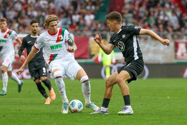 in duel, action, with Kristijan Jakic 17 FC Augsburg , Joakim Maehle 21 VfL Wolfsburg , FC Augsburg vs VfL Wolfsburg, Soccer, 1 Bundesliga, 6 Matchday, 04 10 2025 DFB regulations prohibit any use of photographs as image sequences and or quasi video Augsburg Bayern Germany Copyright: xkolbert-press ChristianxKolbertx