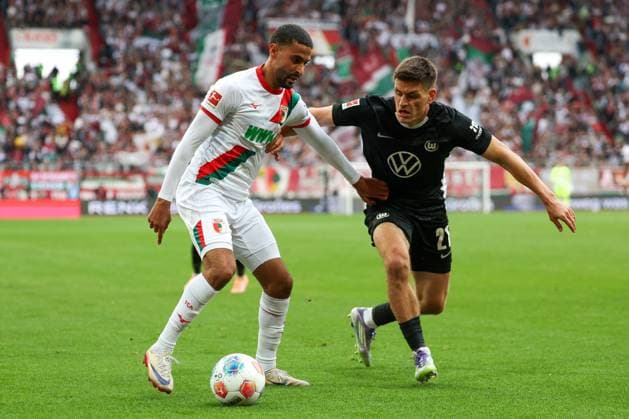 in duel, action, with Elias Saad 26 FC Augsburg , Joakim Maehle 21 VfL Wolfsburg , FC Augsburg vs VfL Wolfsburg, Soccer, 1 Bundesliga, 6 Matchday, 04 10 2025 DFB regulations prohibit any use of photographs as image sequences and or quasi video Augsburg Bayern Germany Copyright: xkolbert-press ChristianxKolbertx
