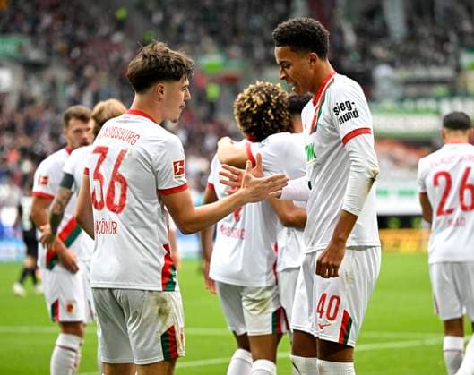 04 10 2025, Soccer 1 Bundesliga 2025 2026, Matchday 6, FC Augsburg VfL Wolfsburg, in the WWK Arena Augsburg Mert Kömür FC Augsburg cheers with Noahkai Dominic Banks FC Augsburg DFL and DFB regulations prohibit any use of photographs as image sequences and or quasi video