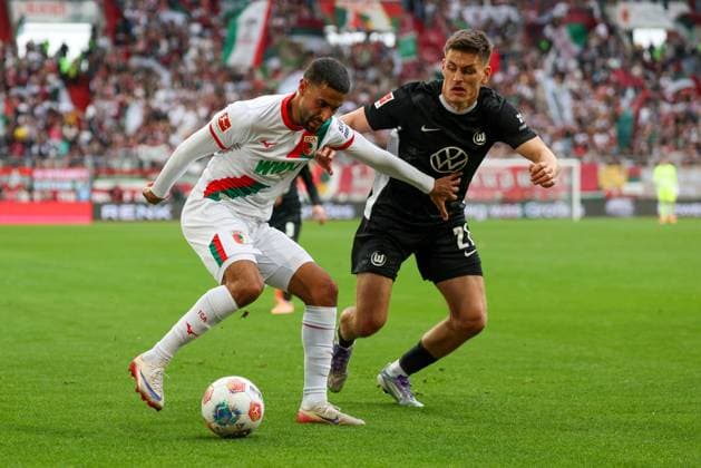 in duel, action, with Elias Saad 26 FC Augsburg , Joakim Maehle 21 VfL Wolfsburg , FC Augsburg vs VfL Wolfsburg, Soccer, 1 Bundesliga, 6 Matchday, 04 10 2025 DFB regulations prohibit any use of photographs as image sequences and or quasi video Augsburg Bayern Germany Copyright: xkolbert-press ChristianxKolbertx