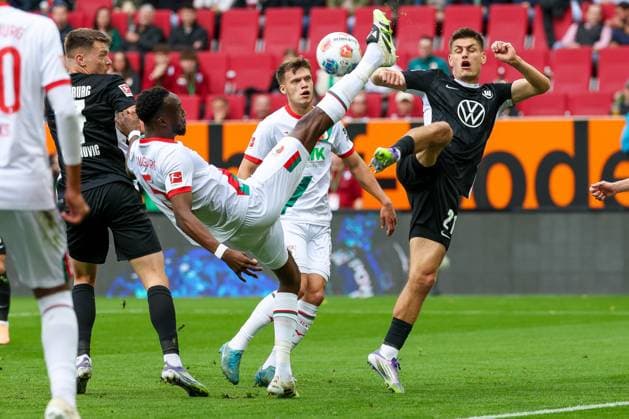 in duel, action, with Chrislain Matsima 5 FC Augsburg , Joakim Maehle 21 VfL Wolfsburg , FC Augsburg vs VfL Wolfsburg, Soccer, 1 Bundesliga, 6 Matchday, 04 10 2025 DFB regulations prohibit any use of photographs as image sequences and or quasi video Augsburg Bayern Germany Copyright: xkolbert-press MarcxMarasescux