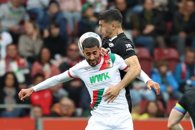 in duel, action, with Elias Saad 26 FC Augsburg , FC Augsburg vs VfL Wolfsburg, Soccer, 1 Bundesliga, 6 Matchday, 04 10 2025 DFB regulations prohibit any use of photographs as image sequences and or quasi video Augsburg Bayern Germany Copyright: xkolbert-press MarcxMarasescux