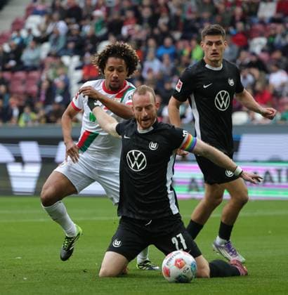 04 10 2025, 1 Bundesliga , FC Augsburg vs VfL Wolfsburg, WWK Arena Augsburg , Soccer, Sports, in the picture Han Noah Massengo FC Augsburg fault Maximilian Arnold VfL Wolfsburg , Joakim Maehle VfL Wolfsburg looks on