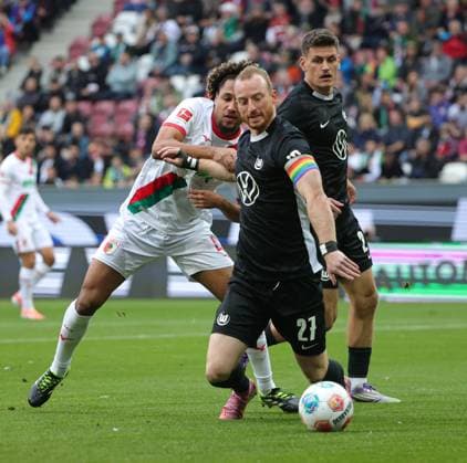 04 10 2025, 1 Bundesliga , FC Augsburg vs VfL Wolfsburg, WWK Arena Augsburg , Soccer, Sports, in the picture Han Noah Massengo FC Augsburg fault Maximilian Arnold VfL Wolfsburg , Joakim Maehle VfL Wolfsburg looks on