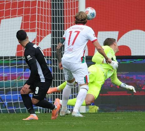 04 10 2025, 1 Bundesliga , FC Augsburg vs VfL Wolfsburg, WWK Arena Augsburg , Soccer, Sports, in the picture Mohamed Amoura VfL Wolfsburg shoots narrowly wide, Kristijan Jakic FC Augsburg and Finn Dahmen FC Augsburg beaten