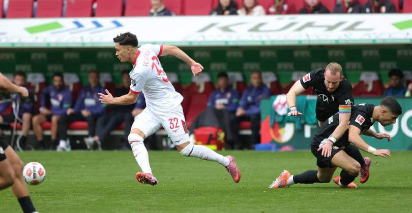 04 10 2025, 1 Bundesliga , FC Augsburg vs VfL Wolfsburg, WWK Arena Augsburg , Soccer, Sports, in the picture Fabian Rieder FC Augsburg leaves Maximilian Arnold VfL Wolfsburg and Moritz Jens VfL Wolfsburg behind
