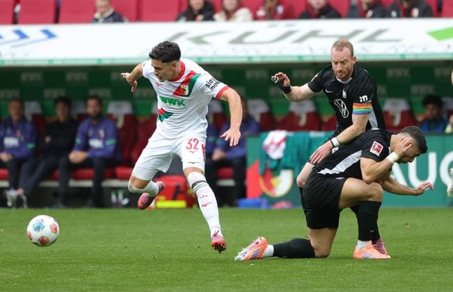 04 10 2025, 1 Bundesliga , FC Augsburg vs VfL Wolfsburg, WWK Arena Augsburg , Soccer, Sports, in the picture Fabian Rieder FC Augsburg leaves Maximilian Arnold VfL Wolfsburg and Moritz Jens VfL Wolfsburg behind