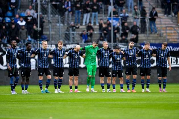 The players of SV Waldhof Mannheim before kick-off during a minutes silence for the deceased honorary member and former member of the presidium Manfred Göth Männel , before the start of the match, silence, mourning, remembrance, minutes silence, in memory, sympathy, speechlessness, action, action, 04 10 2025, Mannheim Germany , Football, 3 Liga, SV Waldhof Mannheim VfL Osnabrück, DFB DFL REGULATES PROHIBIT ANY USE OF PHOTOGRAPHS AS IMAGE SEQUENCES AND OR QUASI VIDEO xozx