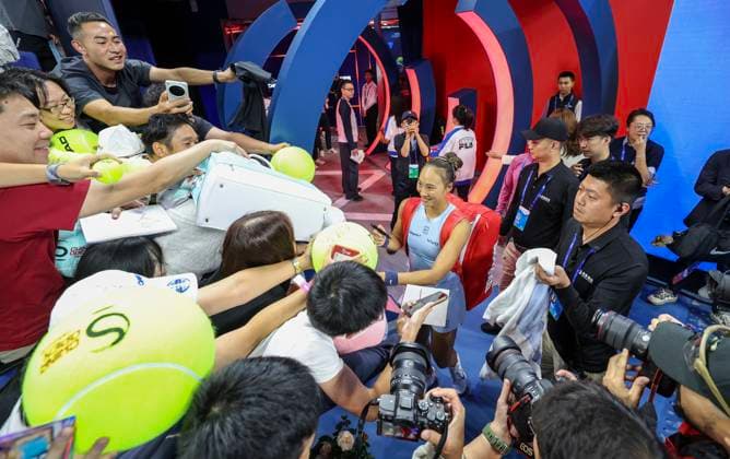 (251005) -- BEIJING, Oct. 5, 2025 -- Zheng Qinwen (C) of China signs an autograph after the women s singles second round match against Emiliana Arango of Colombia at 2025 China Open tennis tournament in Beijing, China, Sept. 27, 2025. ) Xinhua Headlines: Sports events ignite new engine for China s holiday economy BaixXuefei 