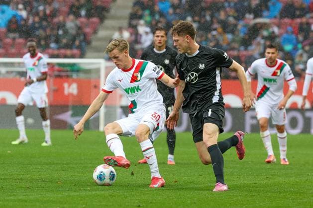 in duel, action, with Anton Kade 30 FC Augsburg , Andreas Skov Olsen 7 VfL Wolfsburg , FC Augsburg vs VfL Wolfsburg, Football, 1 Bundesliga, 6 Matchday, 04 10 2025 DFB regulations prohibit any use of photographs as image sequences and or quasi video Augsburg Bayern Germany Copyright: xkolbert-press ChristianxKolbertx