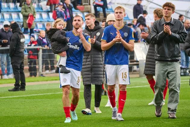 04 10 2025, Soccer, Men, 2 BL Bundesliga , Season 2025 2026, Holstein Kiel SV Darmstadt 98, 8 Matchday Marco Komenda with child, Kasper Davidsen next to Kiel, Holstein Stadion Holstein Stadion Schleswig Holstein Germany