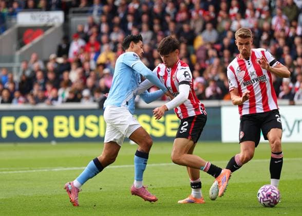 5th October 2025; Gtech Community Stadium, Brentford, London, England; Premier League Football, Brentford versus Manchester City; Tijjani Reijnders of Manchester City dispossessed by Aaron Hickey of Brentford  JohnxPatrickxFletcher
