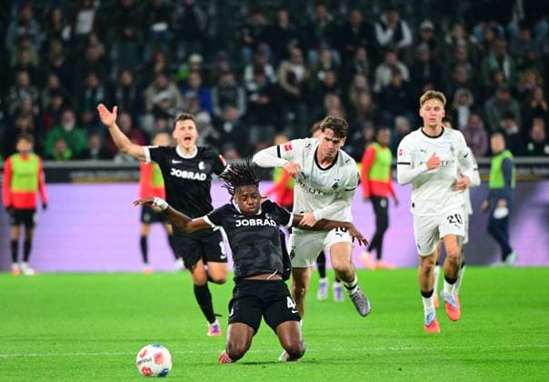 05 10 2025 Moenchengladbach Football, Men, Season 2025 2026, Borussia Moenchengladbach vs SC Freiburg duel between Johan Manzambi Freiburg, front , Philipp Sander Gladbach, back DFL regulations prohibit any use of photographs as image sequences and or quasi video Borussia Park NRW Germany