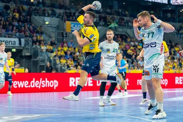 Jannik Kohlbacher 80 Rhein Neckar Löwen throws on goal while Ludvig Jurmala 25 FAG and David Schmidt 77 FAG defend Jannik Kohlbacher 80 Rhein Neckar Löwen throws on goal Copyright: xSpeedshotx
