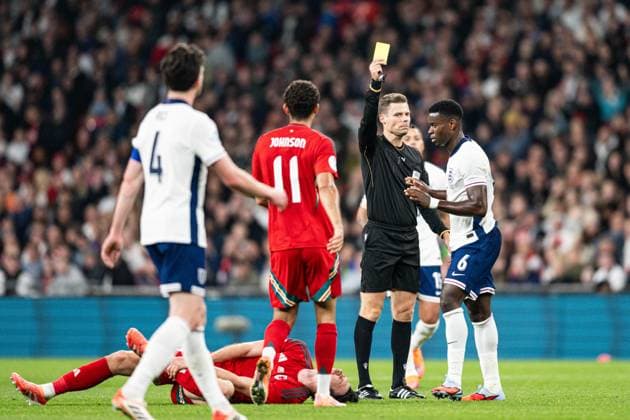 9th October 2025; Wembley Stadium, London, England; Friendly International Football, England versus Wales; Referee Urs Schnyder issues a yellow card to Marc Guehi of England  GodfreyxPitt