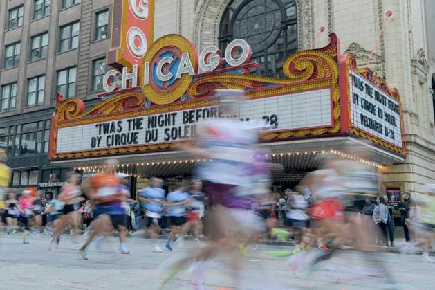 Runners of the Bank of America Chicago pass by the historic Chicago Theater along State Street in Chicago on Sunday, October 12, 2025.  CHI20251012124 MARKxBLACK