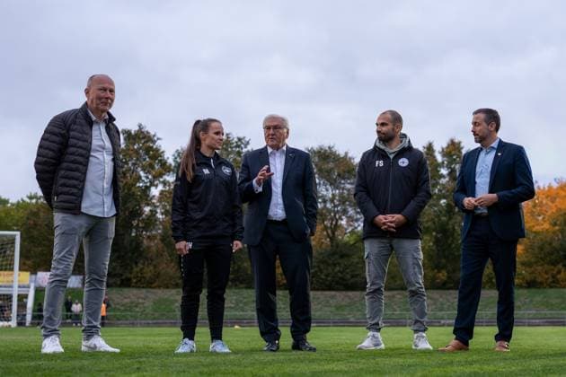 14 10 2025, GER, Visit by the Federal President to a training session of the SG 99 Andernach womens soccer team from left to right Team manager Bodo Heinemann, coach Isabelle Hawel, Federal President Frank Walter Steinmeier, Managing Director Florian Stein and Lord Mayor Christian Greiner in conversation on the training pitch