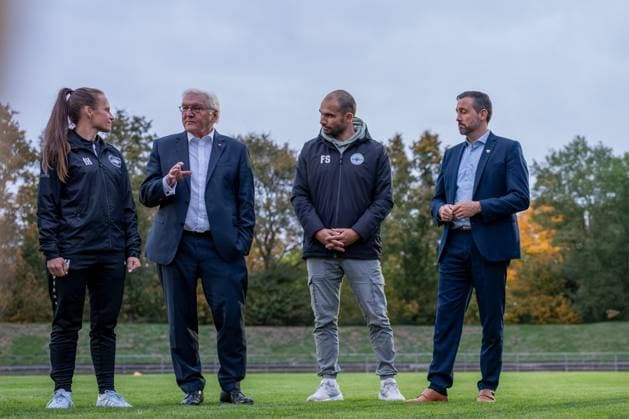 14 10 2025, GER, Visit by the Federal President to a training session of the SG 99 Andernach womens soccer team from left to right Coach Isabelle Hawel, Federal President Frank Walter Steinmeier, Managing Director Florian Stein and Lord Mayor Christian Greiner in conversation on the pitch