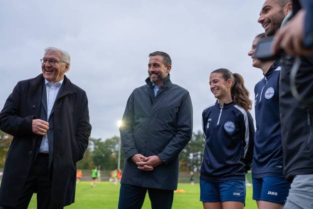 14 10 2025, GER, Visit by the Federal President to a training session of the SG 99 Andernach womens soccer team Federal President Frank Walter Steinmeier, Lord Mayor Christian Greiner, captains Lisa Kossmann and Magdalena Schumacher and Managing Director Florian Stein hold talks on the sidelines of the pitch