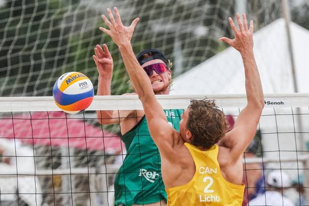 (251015) -- LAGUNA PROVINCE, Oct. 15, 2025 -- Oliver Merritt (L) of Australia spikes the ball against Martin Licht of Canada during the men s qualification match between Ben Hood Oliver Merritt of Australia and Luke de Greef Martin Licht of Canada at the Volleyball World Beach Pro Tour in Laguna Province, the Philippines, Oct. 15, 2025. ) (SP)THE PHILIPPINES-LAGUNA PROVINCE-VOLLEYBALL WORLD BEACH PRO TOUR ROUELLExUMALI 
