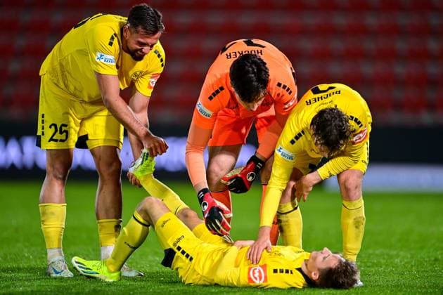 from left Alexander Seidel Bayreuth, 27 pushes a cramp out of the right leg of Dennis Lippert Bayreuth, 3 who is lying on the ground, Lino Kasten goalkeeper, Bayreuth, 45 and Leon Bucher Bayreuth, 2 , 17 10 2025, Unterhaching Germany , Soccer, Regionalliga Bayern, SpVgg Unterhaching SpVgg Bayreuth xslx