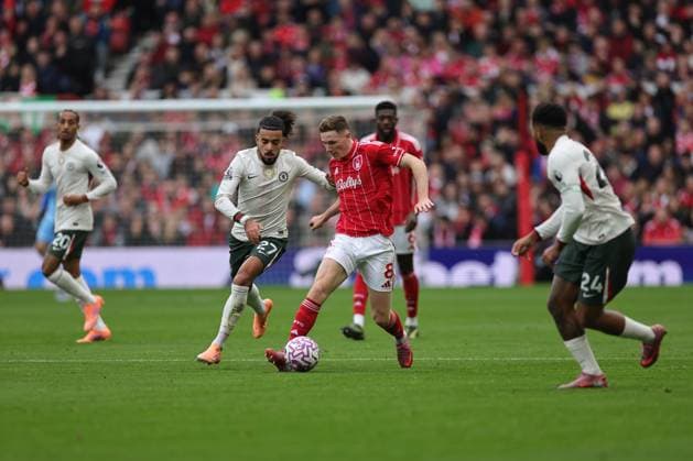 NOTTINGHAM, ENGLAND - OCTOBER 18: Elliot Anderson of Nottingham Forest runs with the ball under pressure from Malo Gusto of Chelsea during the Premier League match between Nottingham Forest and Chelsea at City Ground on October 18, 2025 in Nottingham, England. (Photo by James Holyoak) SPO 