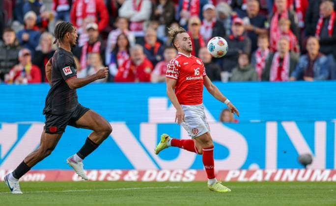 DEU, Mainz, FSV Mainz 05 vs Bayer Leverkusen, Bundesliga, DFB, MEWA Arena, Matchday 7, in the picture from left to right Loïc Badï Bayer Leverkusen 5 , Benedict Hollerbach Mainz 05 17 in a duel DFB DFL REGULATIONS PROHIBIT ANY USE OF PHOTOGRAPHS AS IMAGE SEQUENCES AND OR QUASI VIDEO, 18 10 2025 Copyright: HMBxMedia HendrikxHamelau