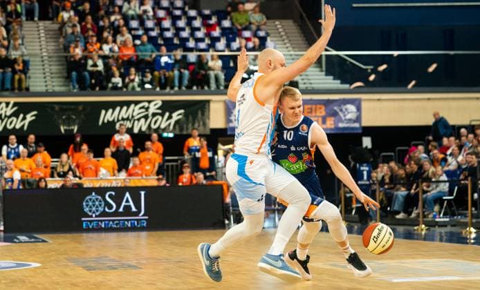 19 10 2025, Basketball, Men, BBL Cup, BBL, Round of 16, Rostock Seawolves Science City Jena Åukasz Kolenda Rostock Seawolves, right against Robin Christen Science City Jena, left Rostock Stadthalle Mecklenburg-Vorpommern Germany