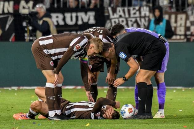 James Sands Pauli lies on the ground Eric Smith Pauli Referee Sven Jablonski with him Germany , Hamburg , Millerntorstadion , Football , 1 Bundesliga , FC St Pauli TSG Hoffenheim