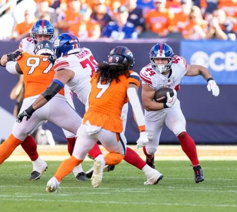 October 19, 2025, Denver, Colorado, USA: Giants RB CAM SCATTEBO readies to collide with Broncos S TALANOA HUFANGA during the 2nd. Half at Empower Field at Mile High Sunday afternoon. Broncos beat the Giants 33-32. Denver USA - ZUMAav4_ 20251019_zaf_av4_041 Copyright: xHectorxAcevedox