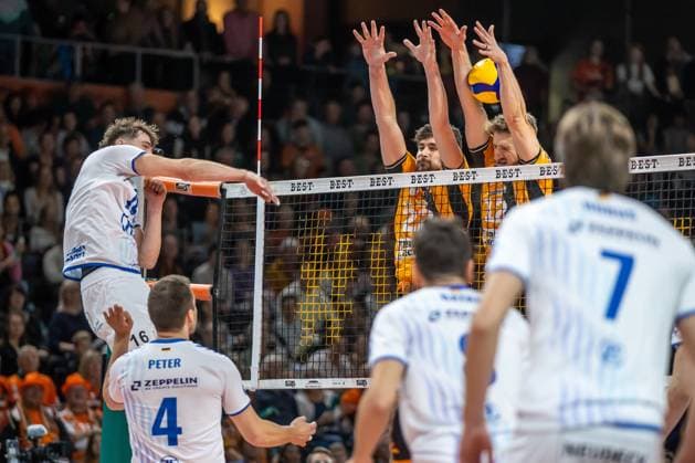 Volleyball Bundesliga, Matchday 1, BR Volleys vs VfB Friedrichshafen at the Max Max Schmeling Halle in Berlin on 21 10 2025 Simon Kohn from VfB Friedrichshafen plays the ball against the block of Jake Hanes BR Volleys and Florian Krage BR Volleys Volleyball Bundesliga, BR Volleys vs VfB Friedrichshafen