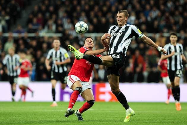 Newcastle Upon Tyne, England, 21st October 2025. Dan Burn of Newcastle United clears the ball under pressure from Franjo IvanoviÄ‡ of Benfica during the Newcastle United vs Benfica UEFA Champions League match at St. James Park, Newcastle Upon Tyne. Picture credit should read: Nigel Roddis Sportimage EDITORIAL USE ONLY. No use with unauthorised audio, video, data, fixture lists, club league logos or live services. Online in-match use limited to 120 images, no video emulation. No use in betting, games or single club league player publications. SPI_045_NR_NEWC_BENF SPI-4229-0043