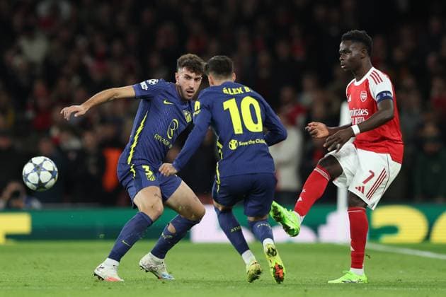 London, England, 21st October 2025. Bukayo Saka of Arsenal plays the ball past Matteo Ruggeri (L) and Alex Baena of Atletico Madrid during the Arsenal vs Atletico Madrid UEFA Champions League match at the Emirates Stadium, London. Picture credit should read: Kieran Cleeves Sportimage EDITORIAL USE ONLY. No use with unauthorised audio, video, data, fixture lists, club league logos or live services. Online in-match use limited to 120 images, no video emulation. No use in betting, games or single club league player publications. SPI_060_KC_Arsenal_v_Atletico_Madrid SPI-4228-0061