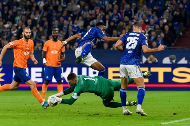 Moussa Sylla (FC Schalke) und Torwart Marcel Schuhen (SV Darmstadt 98) im Kampf um den Ball waehrend des spiels der 2. Bundesliga zwischen FC Schalke 04 und SV Darmstadt 98 Veltins-Arena am 24. October 2025 in Gelsenkirchen, Deutschland. (Foto von Max Maiwald DeFodi Images) +++ Moussa Sylla (FC Schalke) und Torwart Marcel Schuhen (SV Darmstadt 98) battle for the ball during the 2. Bundesliga match between FC Schalke 04 and SV Darmstadt 98 at Veltins-Arena on October 24, 2025 in Gelsenkirchen, Germany. (Photo by Max Maiwald DeFodi Images) DFB DFL REGULATIONS PROHIBIT ANY USE OF PHOTOGRAPHS AS IMAGE SEQUENCES AND OR QUASI-VIDEO. (Photo by Max Maiwald DeFodi Images) Moussa Sylla FC Schalke and goalkeeper Marcel Schuhen SV Darmstadt 98 battle for the ball during the 2 Bundesliga match between FC Schalke 04 and SV Darmstadt 98 Veltins Arena on October 24, 2025 in Gelsenkirchen, Germany Photo by Max Maiwald DeFodi Images Moussa Sylla FC Schalke and goalkeeper Marcel Schuhen SV Darmstadt 98 battle for the ball during the 2 Bundesliga match between FC Schalke 04 and SV Darmstadt 98 at Veltins Arena on October 24, 2025 in Gelsenkirchen, Germany Photo by Max Maiwald DeFodi Images DFB DFL REGULATIONS PROHIBIT ANY USE OF PHOTOGRAPHS AS IMAGE SEQUENCES AND OR QUASI VIDEO Photo by Max Maiwald DeFodi Images