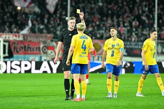 Soccer I Men I Season 2025 2026 I Regionalliga I Matchday 13 I Hallescher FC 1 FC Lokomotive Leipzig I 24 10 2025 Referee Marvin Tennes shows Jan Philipp Stein 4, 1 FC Lokomotive Leipzig the yellow card after the foul on Halles Elezi Halle Saale Leuna Chemie Stadion Sachsen Anhalt Germany Copyright: xLobeca InesxHähnelx