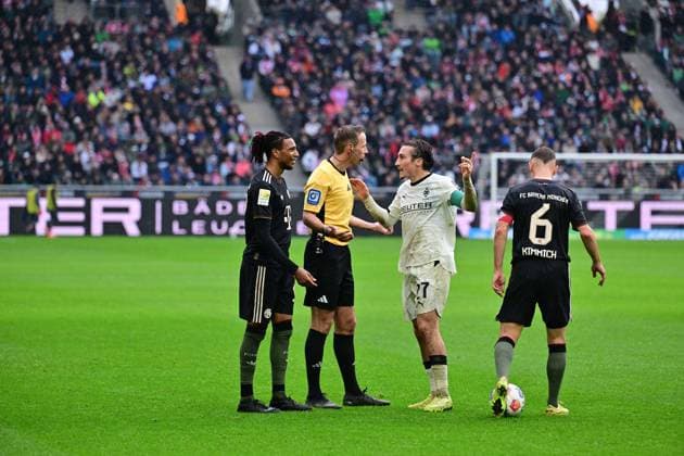 25 10 2025 Moenchengladbach Fussball, Herren, Saison 2025 2026, Borussia Moenchengladbach vs Bayern Muenchen Much need for discussion with referee Sascha Stegemann f li Michael Olise Bayern , referee Sascha Stegemann, Rocco Reitz Gladbach , Joshua Kimmich Bayern DFL regulations prohibit any use of photographs as image sequences and or quasi video Borussia Park NRW Germany